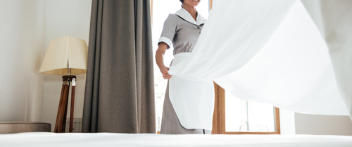 Hotel maid changing bed sheet